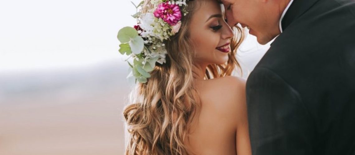 portrait of a girl and couples looking for a wedding dress, a pink dress flying with a wreath of flowers on her head on a background tsvetu chicago garden and the blue sky, and they hug and pose